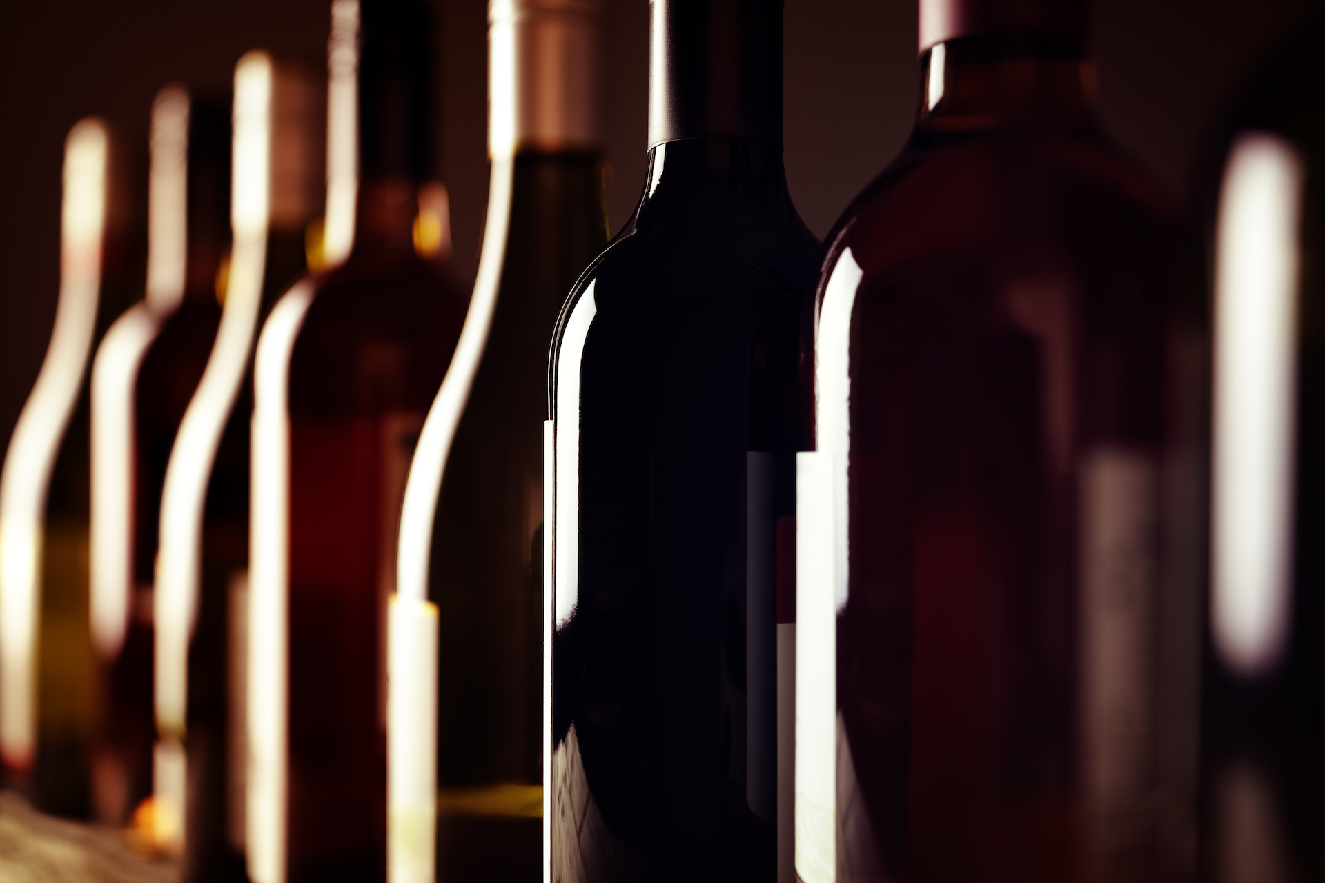 Bottles of old aged wine collection in a row in winery cellar